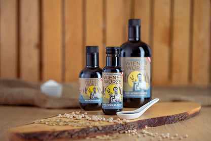 Würzsaucen Genusskoarl Bio-WienerWuerze in 100 ml, 250 ml und 750 ml Flasche auf Holzbrett