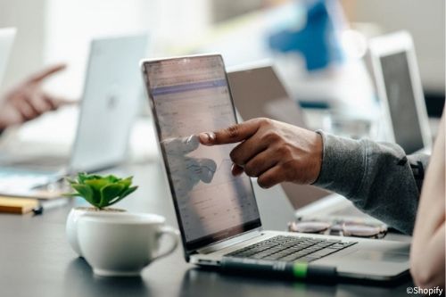 Mann zeigt auf einen Laptop-Bildschirm